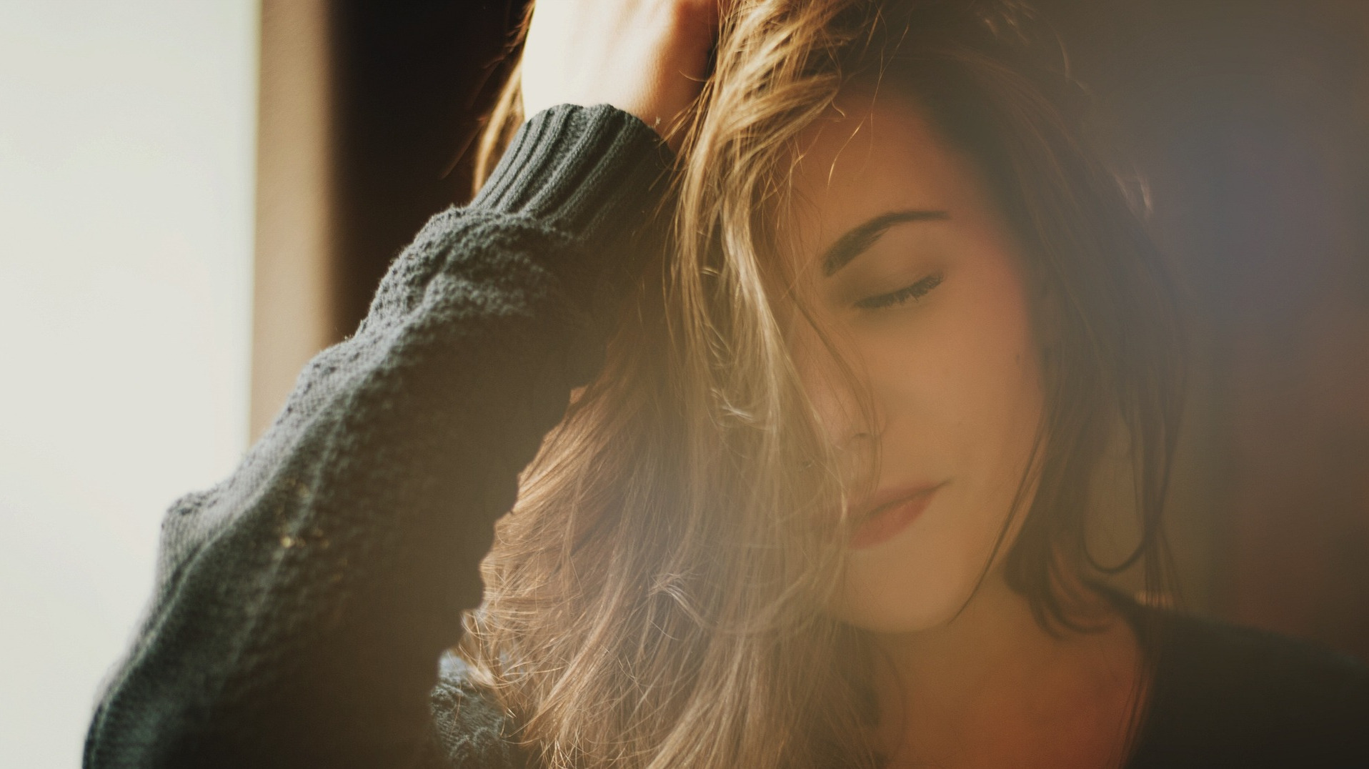 Brunette haired woman touching scalp