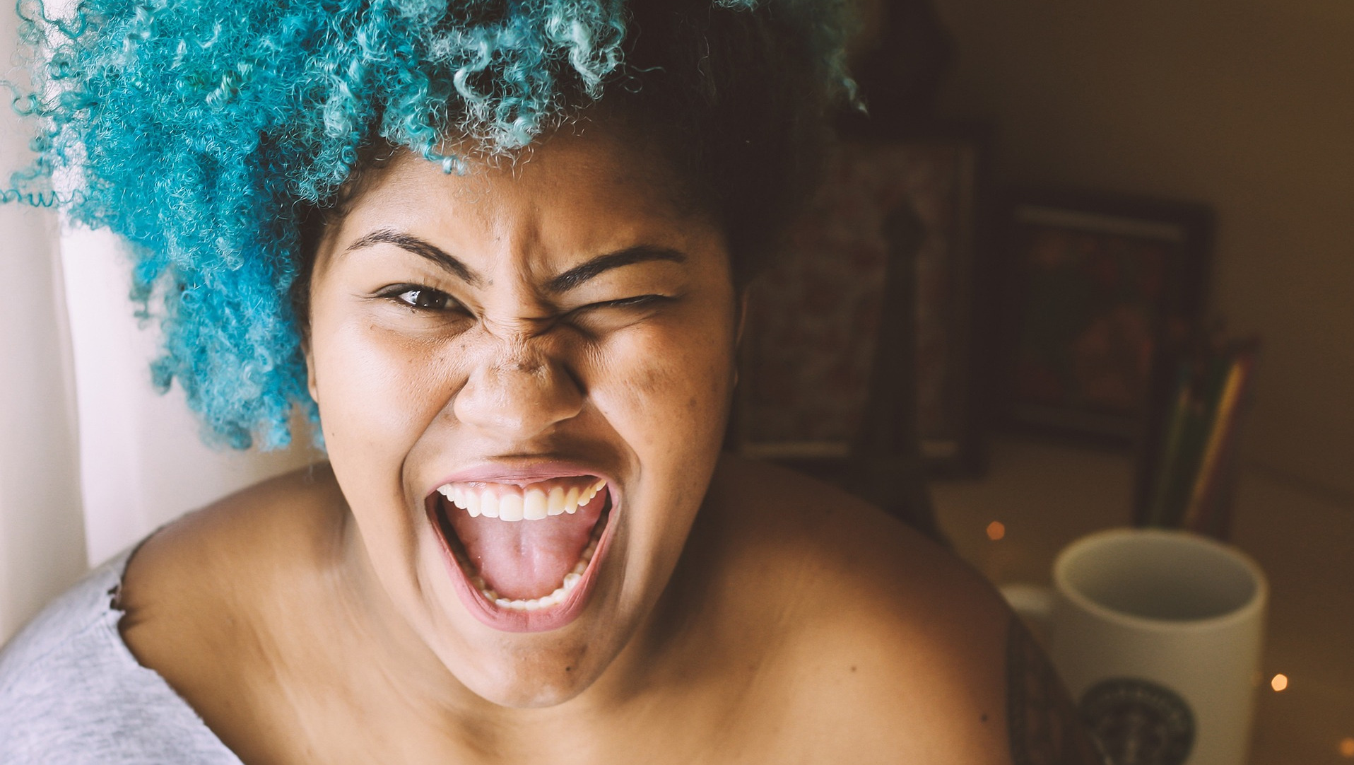 Smiling woman with blue hair and white teeth