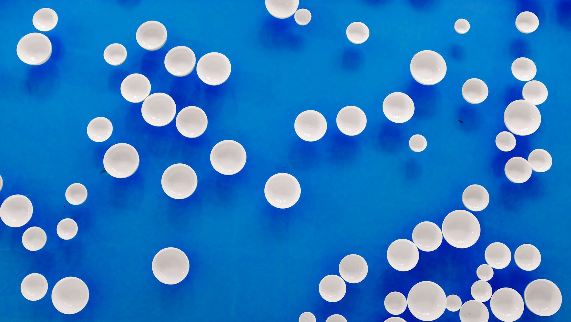 White balls on a blue background. Metaphor for cysts